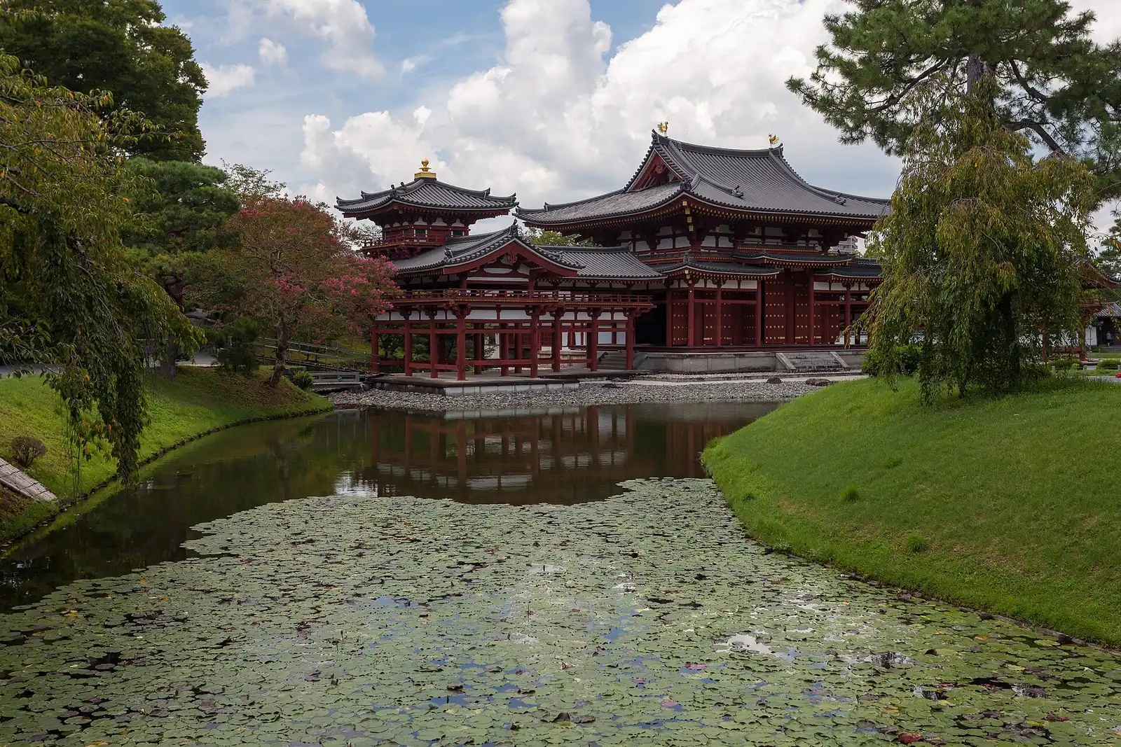 Japanese garden at Byōdō-in: the red Phoenix Hall beside a pond covered with floating leaves, trees on both banks